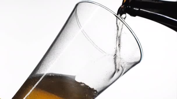 Выливание желтого пива на белом фоне. Барм, пузырь свежее питье, пенный золотой спирт . — стоковое видео
