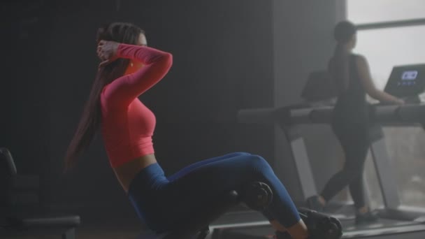 A jovem está treinando seus abdominais no ginásio — Vídeo de Stock