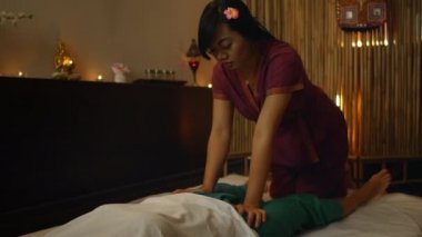 Asyalı kadın güzel Avrupalı kadına geleneksel Tayland masajı yapıyor. Masaj 'ın yardımıyla yaralardan sonra rehabilitasyon ve tedavi. Rahatlayın ve Bacak, Kollar ve Sırt masajından dinlenin.