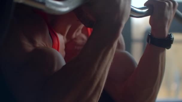 Close-up: een toegewijde atleet tilt een lange halter op met een gewicht voor bicepstraining in de sportschool. Trainingsarmen en biceps. Krachtige man traint hard om het doel te bereiken — Stockvideo