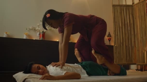 Jonge mooie en gelukkige Amerikaanse toeristische vrouw met traditionele Thaise massage in haar lichaam door Aziatische masseur in de buitenlucht spa. Jong mooi en gelukkig — Stockvideo