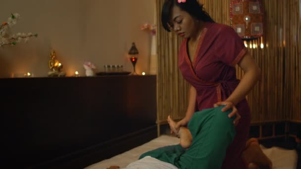 Massage thaï. La femme asiatique frottée par le chiropraticien traditionnel sur son dos avec les mains pour soulager la tension ou la douleur . — Video