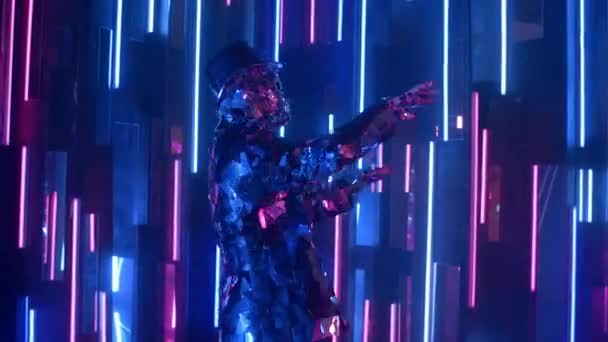 A man dances in neon light in a glass suit. Shiny sparkling silver suit, and blue purple neon light. New year party. — Stock Video