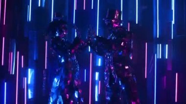 Neon ışıklı çift metalik parlak çift birlikte dans ediyor. Modern cam insanlar, gösteriler neon mavisi pembe ışıkla gösteriliyor. Komik bir dans. Kulüp için müzik ekran koruyucusu.