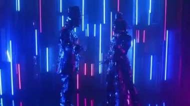 Neon ışıklı çift metalik parlak çift birlikte dans ediyor. Modern cam insanlar, gösteriler neon mavisi pembe ışıkla gösteriliyor. Komik bir dans. Kulüp için müzik ekran koruyucusu.