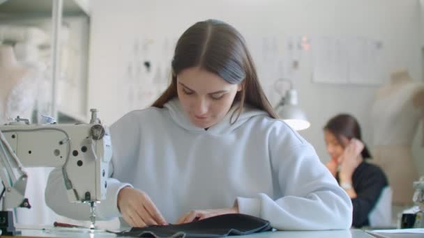 Vista anteriore della stilista di moda femminile che lavora con la macchina da cucire in officina — Video Stock