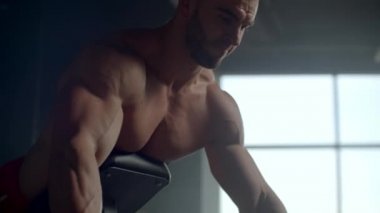 Fitness kulübündeki bir adam eğik bir halterle omurga kasları için egzersiz yapıyor.