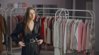 Siyah elbiseli güzel kız mağazadaki aynaya bakıyor. Gece elbisesi deniyorum.