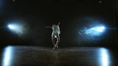 Modern koreografi balerini sahnede yavaş çekimde dans ediyor. Dans müzikali. Ay ışığında dramatik bir sahne