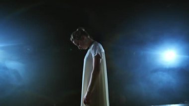 Modern koreografi balerini sahnede yavaş çekimde dans ediyor. Dans müzikali. Ay ışığında dramatik bir sahne