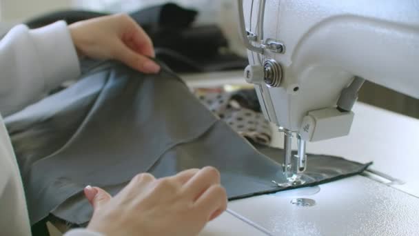 Concepto de pequeña empresa y hobby. Mujer joven diseñadora de ropa que trabaja en una máquina de coser en su estudio. En interiores . — Vídeos de Stock