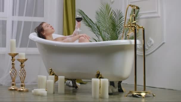 Beber vino acostado en el baño, tumbarse en un baño caliente con vino tinto y no pensar en los problemas. Gestión del estrés — Vídeo de stock