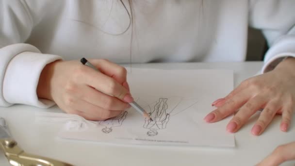 Close-up vrouwen modeontwerpers tekenen schetsen van jurken en pick-up materialen en accessoires. Kleine kleermaker. Modeontwerp creëren. — Stockvideo