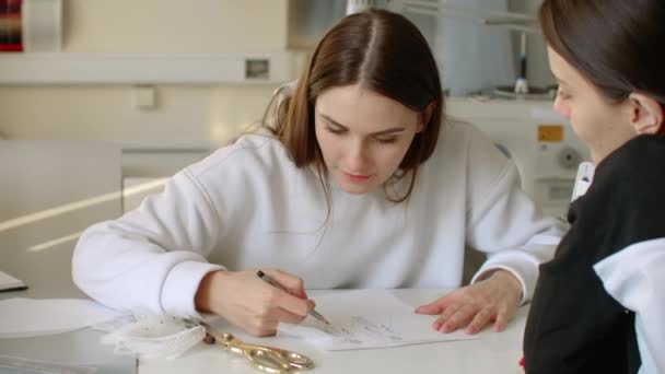 Designer of clothes makes an outline of clothes with a felt-tip pen. female hands close up. — Stock Video