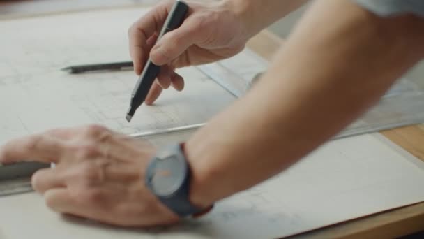 El ingeniero dibuja edificios sobre la mesa usando un lápiz y una regla. Un arquitecto crea un diseño de edificio sobre papel usando un marcador y una regla — Vídeos de Stock