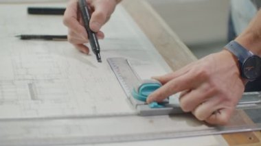 Mimarlar Danışma: çizimler, mezura, cetvel ve diğer çizim araçları. Mühendis inşaat çizimleri parlak bir ofiste ile yakın çekim. Insturments ve ofis Tasarımcısı için. Bir kalem ile erkek el çizmek