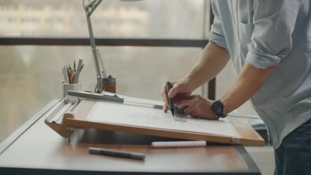 Arquiteto homem de pé trabalhando com plantas esboçando um projeto de construção em madeira mesa em casa office.Construction design concept.vintage tom de cor . — Vídeo de Stock