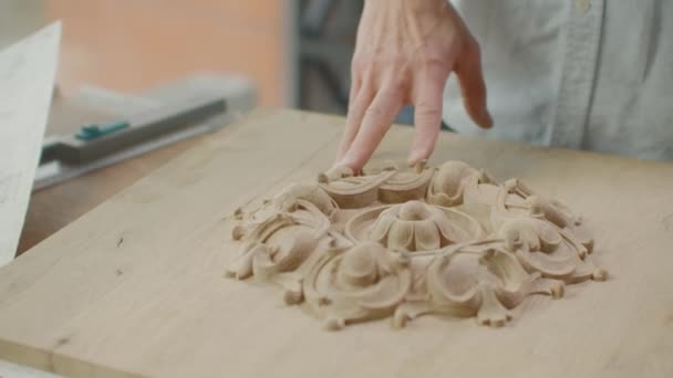 Een mannelijke architect bekijkt tekeningen en plattegronden van gebouwen in een loft tegen een groot raam. De ontwerper plant de gevel van gebouwen. Ontwerp van meubelen. — Stockvideo