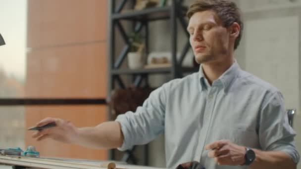 Architecte assis à la table de rédaction dans le bureau industriel moderne pendant la journée 