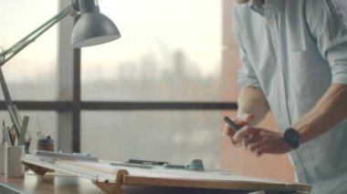 Mimarlar Danışma: çizimler, mezura, cetvel ve diğer çizim araçları. Mühendis inşaat çizimleri parlak bir ofiste ile yakın çekim. Insturments ve ofis Tasarımcısı için. Bir kalem ile erkek el çizmek