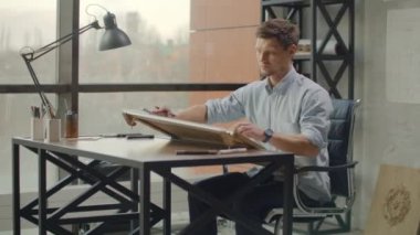 architect man Standing working with blueprints sketching a construction project on wood desk at home office.Construction design concept.vintage color tone.