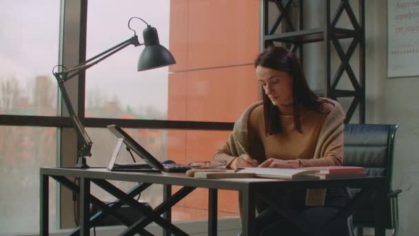 Bir kadın grafik tasarımcı, geniş pencereli ve boyalı bir ofiste bir stil ve bilgisayar ekranı kullanarak çalışır. Tasarımcılar için dokunmatik ekranlı çalışma istasyonu. — Stok video