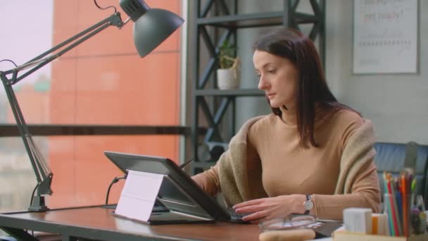 Kobiecy grafik pracuje w biurze z dużymi oknami i farbami za pomocą rysika i ekranu dotykowego komputera. Stacja robocza z ekranem dotykowym dla projektantów. — Wideo stockowe