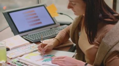 Ofisteki masada grafik tableti kullanırken modern masaüstü bilgisayarı üzerinde çalışan genç grafik tasarımcısı
