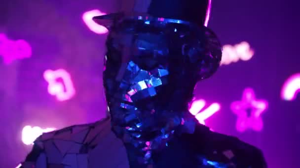 Amuzant om de diamant dansând făcând mișcări ale mâinilor în lumina violet albastru neon. Costum metalic din argint — Videoclip de stoc