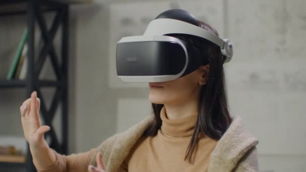 Mujer en un casco de realidad virtual en el contexto de una gran ventana en la oficina en el lugar de trabajo. Ingeniero de diseño trabajando en un casco de realidad virtual — Vídeos de Stock