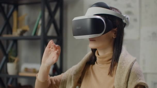 Жінка-інженер у шоломі віртуальної реальності з руками імітує роботу інтерфейсу. Розробка майбутнього, концепція віртуальної архітектури та дизайну, інтерфейсні графічні додатки — стокове відео