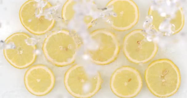 Many fresh lemon, top view of water flowing on a white background — ストック動画