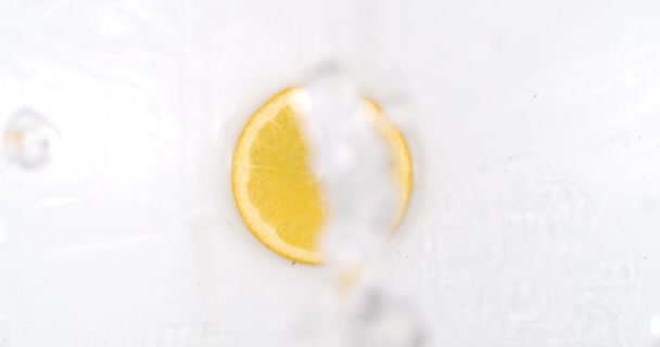 Super Slow Motion Shot of Splashing Water to one orange Slices view from above. — ストック動画