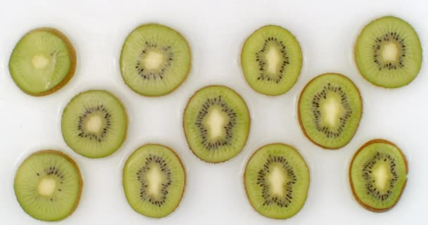 I slow motion, vatten stänk hälla vatten på en vacker saftig citrus frukt en hel del kiwi på en vit bakgrund. — Stockvideo