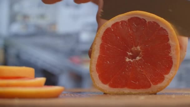 Nařežte grapefruit na dřevěné desce detailně. skartováno — Stock video