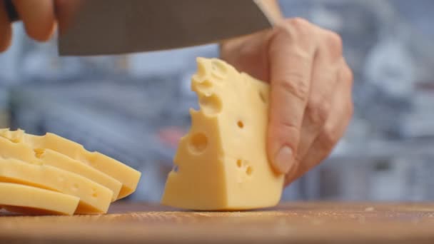 Na dřevěné desce nakrájíme žlutý sýr. skartováno