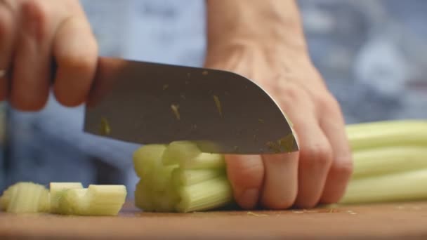 Close-up van gesneden selderij op een plank in de keuken met een mes — Stockvideo