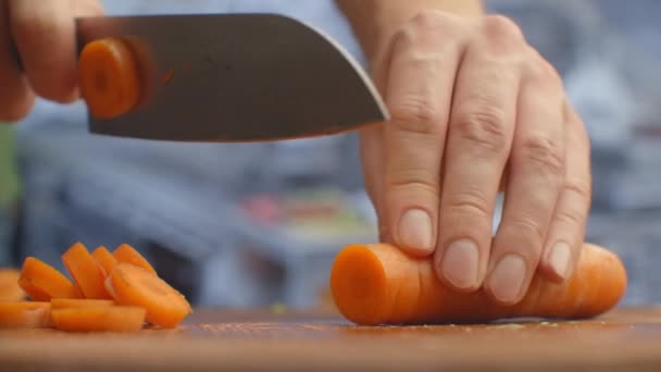 Woman cutting carrot on table, closeup. — Stock Video