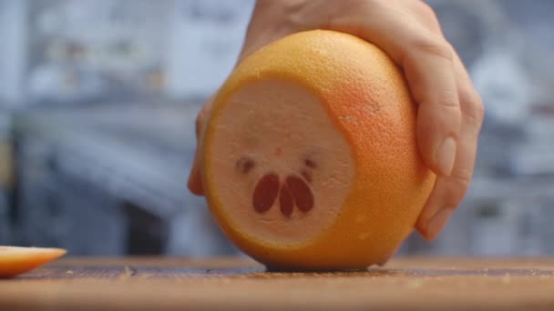 Nařežte grapefruit na dřevěné desce detailně. skartováno