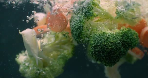 Frisches Gemüse, das in Zeitlupe auf weißem Hintergrund unter Wasser fällt. Salat, gesundes Essen, lecker. Ernährung, vegetarischer Lebensstil, Ökoprodukte, Bio. Vitamine. Nahsicht. — Stockvideo