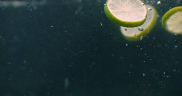 Limes salpicando em água câmera lenta — Vídeo de Stock