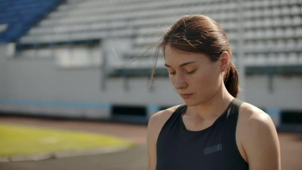 Portret pięknej kobiety biegającej po trybunach stadionu z skoncentrowanym głębokim oddechem i motywującą mnie i świadomość do wyścigu. Pozbądź się zbędnych emocji. — Wideo stockowe