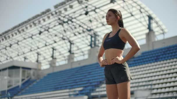 Медленное движение: женщина-спортсмен ждет старта гонки на 400 метров. Девушка-спортсмен ждет старта гонки в течение 100 метров. Бег по стадиону с площадки на беговой дорожке . — стоковое видео