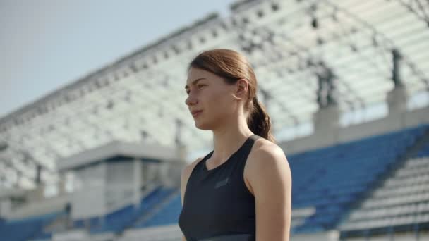 Lassú mozgás: sportoló nő várja a kiindulási blokk futó pályán. — Stock videók