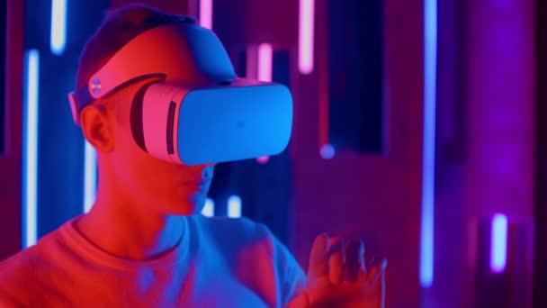Bărbat în picioare încercând căști VR în lumini de neon — Videoclip de stoc