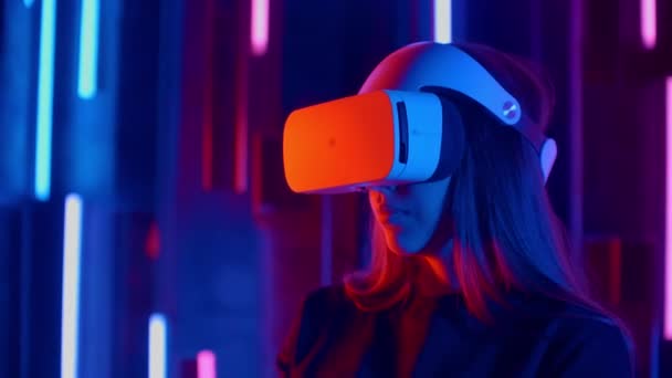 Donna in piedi cercando VR auricolare in luci al neon — Video Stock