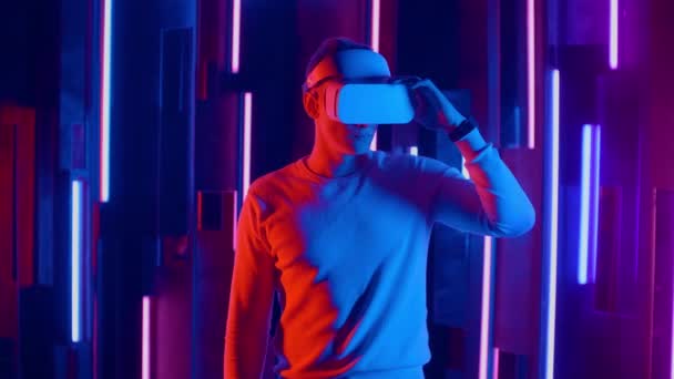 Постійний чоловік намагається VR гарнітуру в неонових вогнях — стокове відео