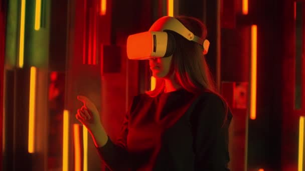 Femme debout essayant casque VR dans les néons — Video
