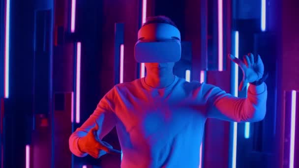 Junger Mann mit Vr-Brille im Neonlicht. — Stockvideo