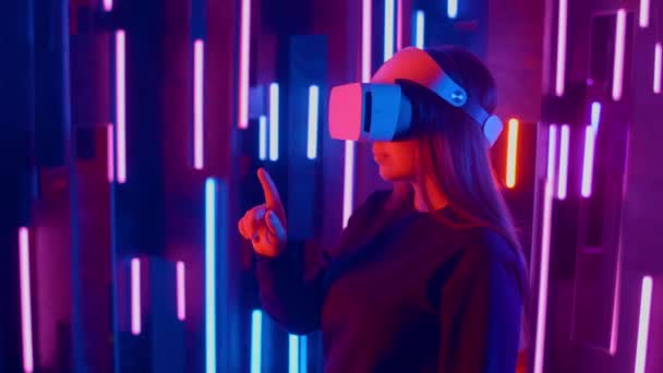 Giovane donna mettendo VR auricolare sullo spettatore in luci al neon — Video Stock